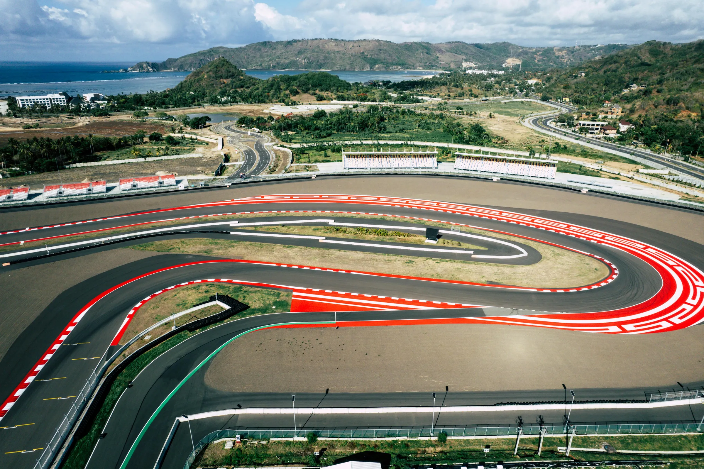 Vue aérienne d'un circuit automobile avec virages serrés et tribunes